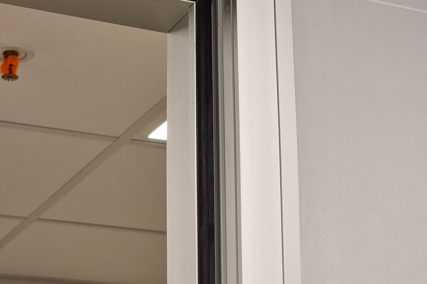 Detail of a custom-developed door: aluminium profile, wood and joint resolved at the plant.